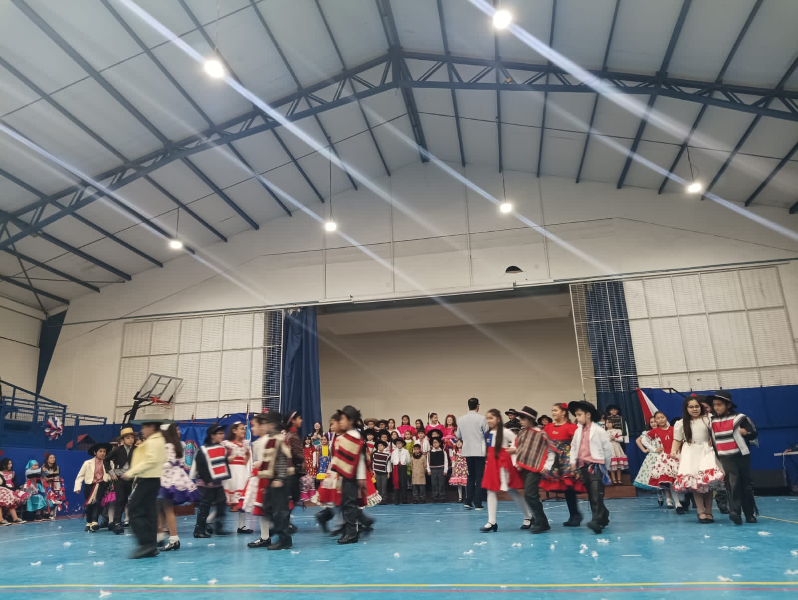 Estudiantes de primer ciclo realizando baile tradicional en acto de fiestas patrias